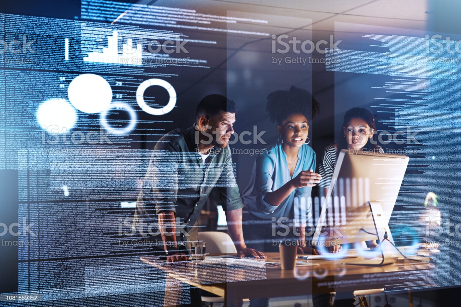 Shot of a group of programmers working together on a computer code at night